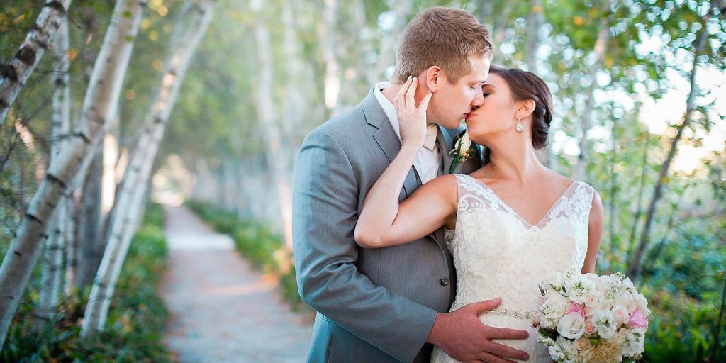Pareja besándose sujetando en sus manos Flores para boda