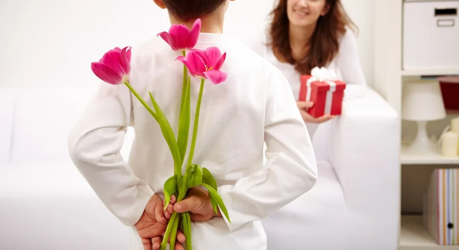 Niño con flores para regalar a su madre en una ocasión especial.